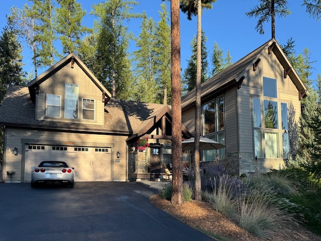 view of front of property with driveway and roof with shingles