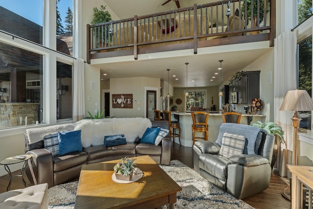 living room featuring dark wood-style floors and a towering ceiling