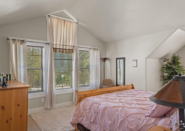 carpeted bedroom featuring baseboards and lofted ceiling