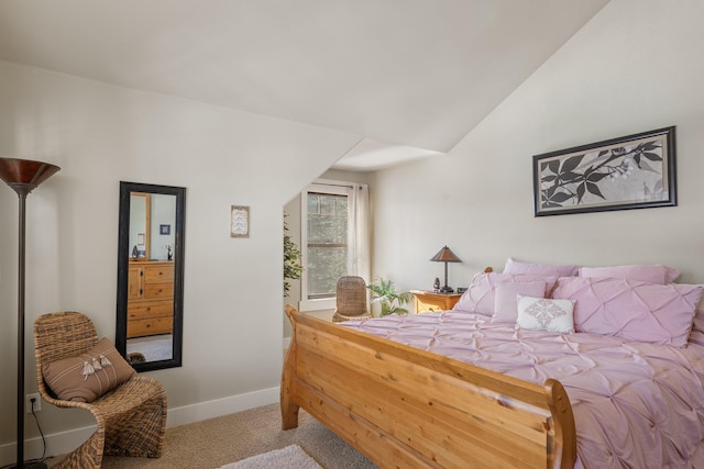 carpeted bedroom with baseboards and vaulted ceiling