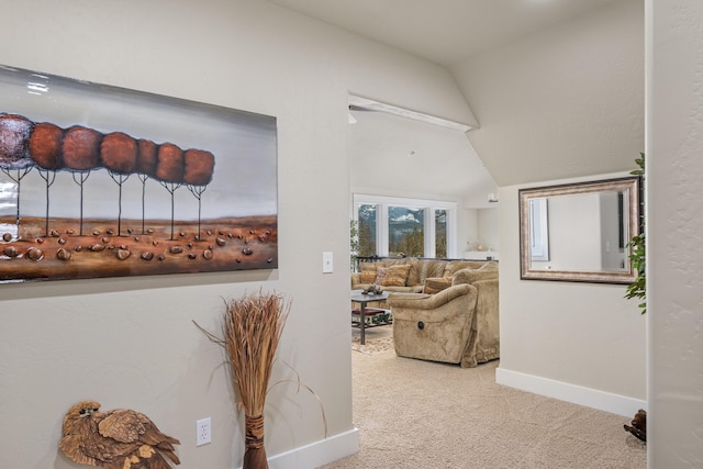 corridor with baseboards, carpet floors, and vaulted ceiling