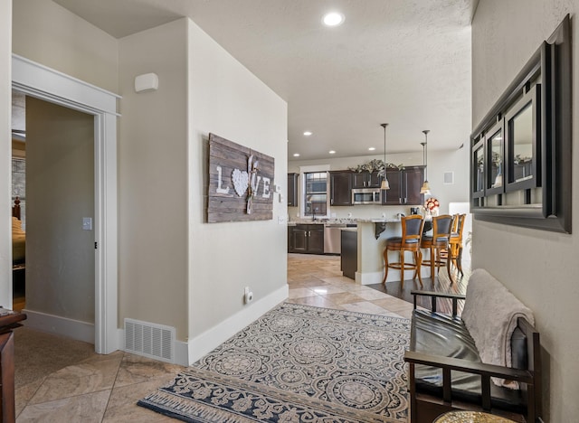 interior space featuring recessed lighting, visible vents, baseboards, and light tile patterned floors