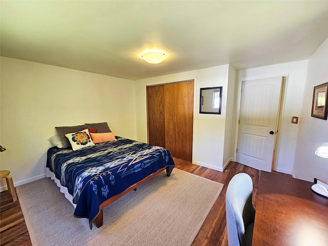 bedroom with a closet, baseboards, and wood finished floors