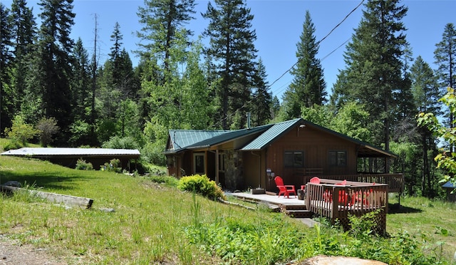 back of property with a standing seam roof, a deck, and metal roof