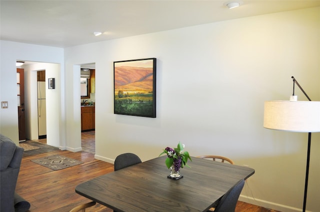 dining space with baseboards and wood finished floors