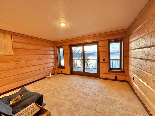 doorway featuring light tile patterned floors and wooden walls