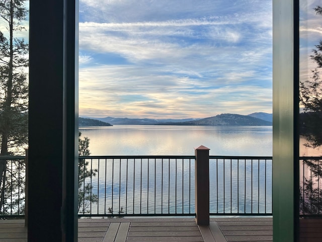 wooden terrace with a water and mountain view