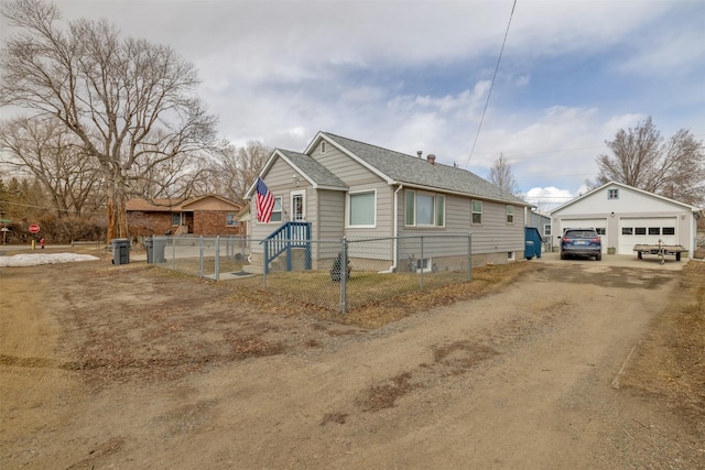 view of front of home with an outbuilding, a shingled roof, a detached garage, and fence