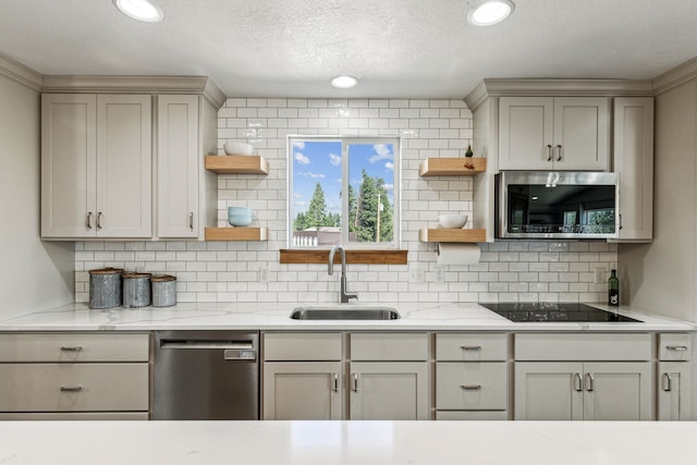 kitchen featuring open shelves, gray cabinetry, appliances with stainless steel finishes, and a sink