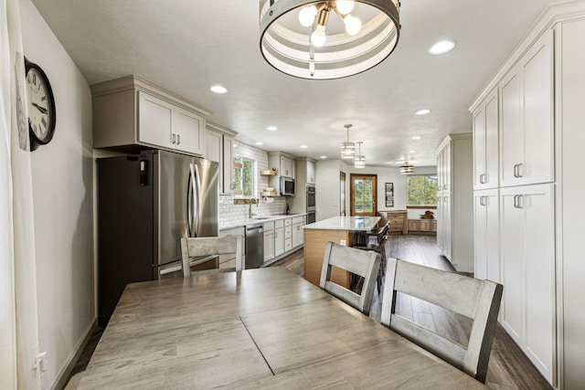 kitchen featuring a wealth of natural light, stainless steel appliances, decorative backsplash, and light countertops