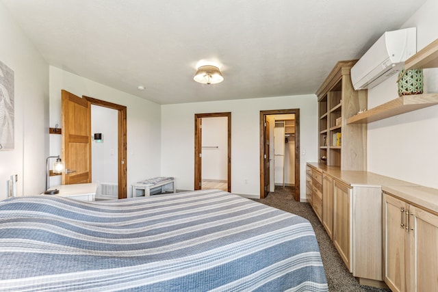 bedroom featuring baseboards, visible vents, a wall mounted AC, a walk in closet, and dark carpet