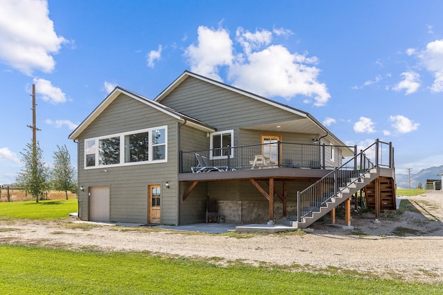 back of property featuring driveway, a patio, a wooden deck, a garage, and stairs