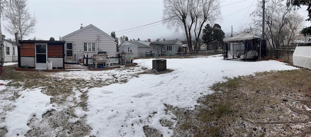 yard layered in snow with a deck and fence