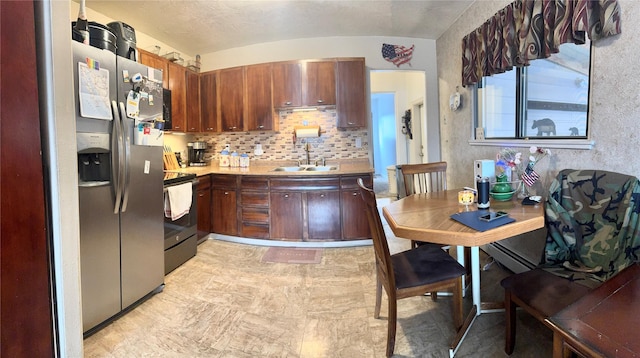 kitchen with electric range, stainless steel refrigerator with ice dispenser, a sink, backsplash, and light countertops