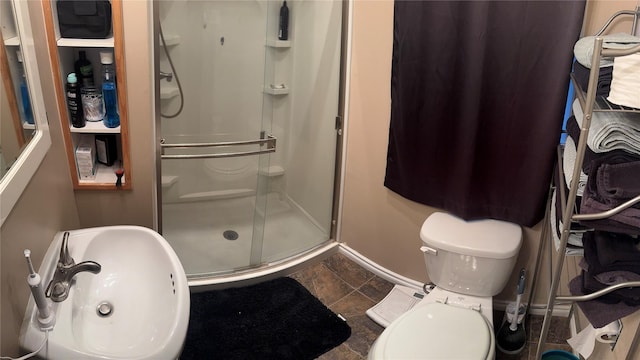 full bath with a sink, toilet, and a stall shower