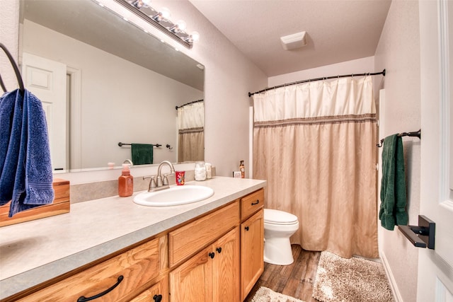 full bath with vanity, curtained shower, toilet, and wood finished floors