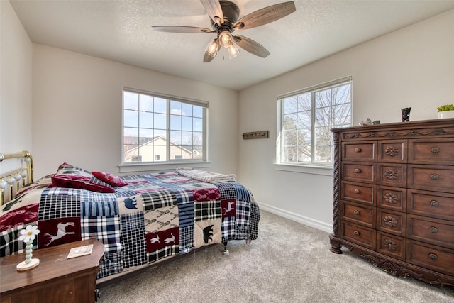 bedroom featuring a ceiling fan, baseboards, carpet floors, and a textured ceiling