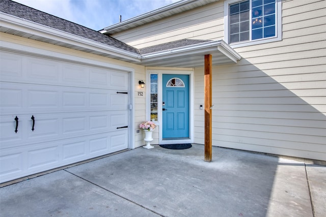 entrance to property featuring driveway and a garage