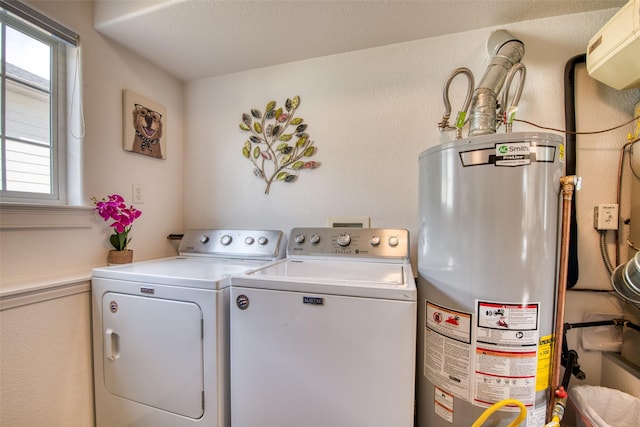 clothes washing area with water heater, laundry area, and washing machine and dryer