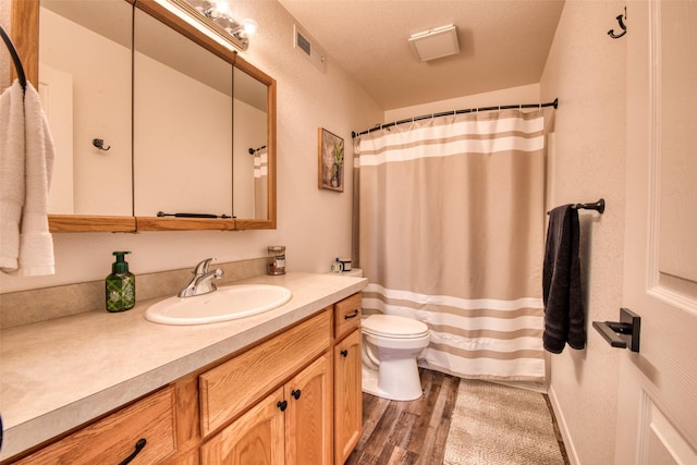 full bath featuring visible vents, toilet, a shower with curtain, wood finished floors, and vanity