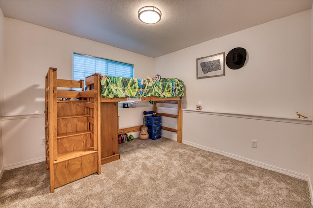 carpeted bedroom featuring a textured ceiling and baseboards