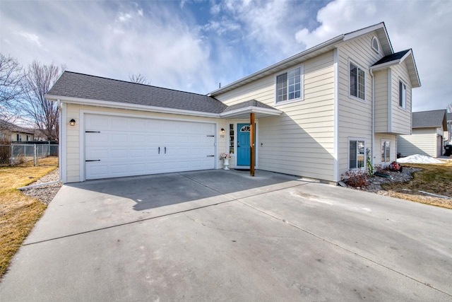 view of front of property featuring an attached garage, concrete driveway, and fence