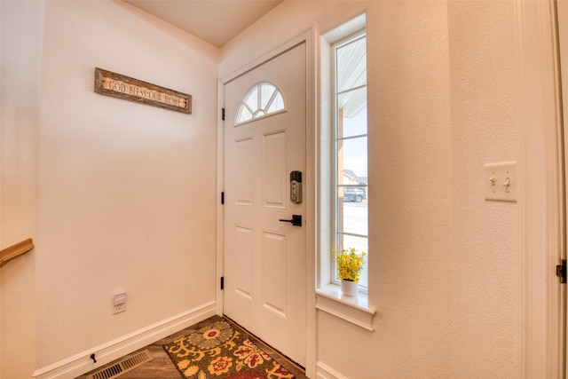 entrance foyer with visible vents, baseboards, and dark wood-style flooring