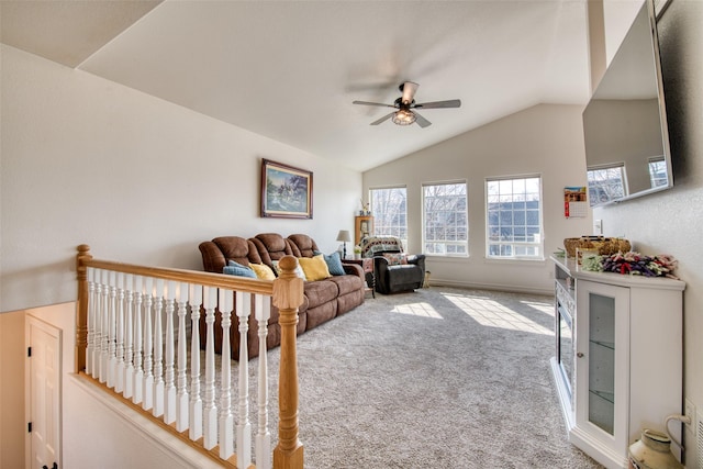 carpeted living area featuring baseboards, lofted ceiling, and a ceiling fan