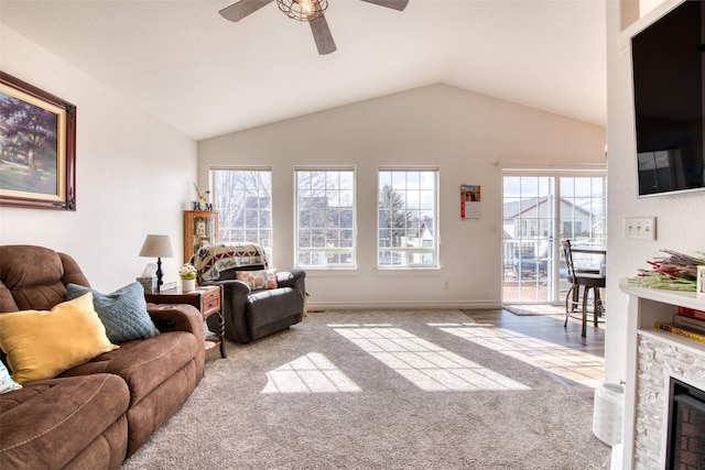 carpeted living area featuring a fireplace, baseboards, lofted ceiling, and a ceiling fan