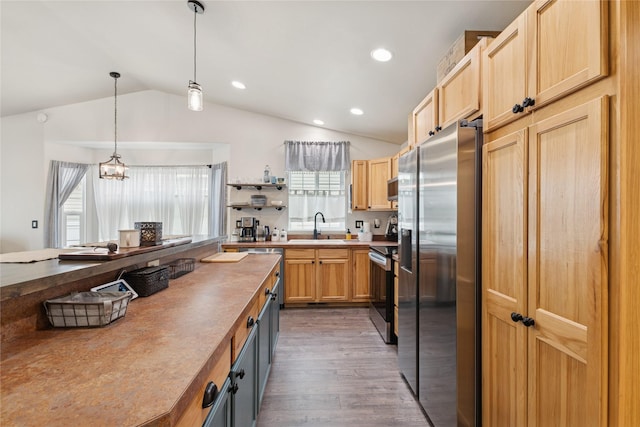 278 Empire Loop, Kalispell, MT 59901 - kitchen featuring stainless steel appliances, vaulted ceiling, a sink, dark wood-type flooring, and decorative light fixtures