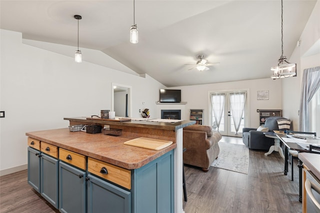 278 Empire Loop, Kalispell, MT 59901 - kitchen featuring vaulted ceiling, dark wood-type flooring, ceiling fan, open floor plan, and a glass covered fireplace