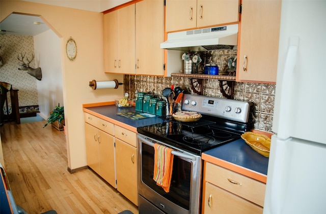 3676 Silverthorn Dr, Stevensville, MT 59870 - kitchen with stainless steel range with electric cooktop, under cabinet range hood, freestanding refrigerator, decorative backsplash, and light wood-style floors