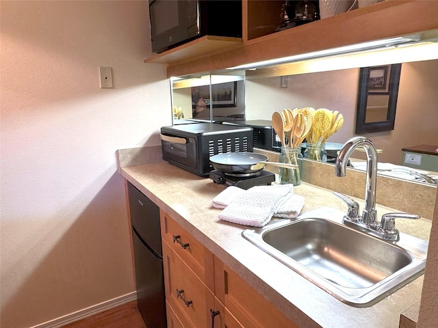 180 Vista Ln Unit 238, Bigfork, MT 59911 - kitchen with a sink, black microwave, light countertops, brown cabinets, and baseboards