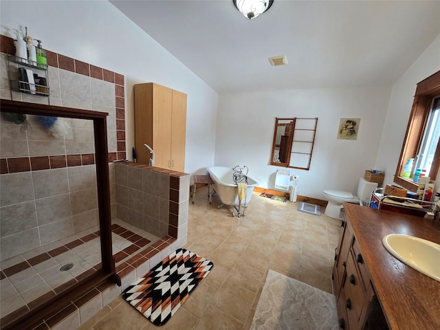 611 S Canyon Dr, Seeley Lake, MT 59868 - bathroom with a soaking tub, a stall shower, vanity, tile patterned flooring, and lofted ceiling