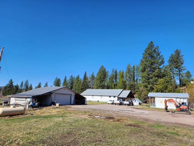 611 S Canyon Dr, Seeley Lake, MT 59868 - view of grassy yard featuring a detached garage and dirt driveway