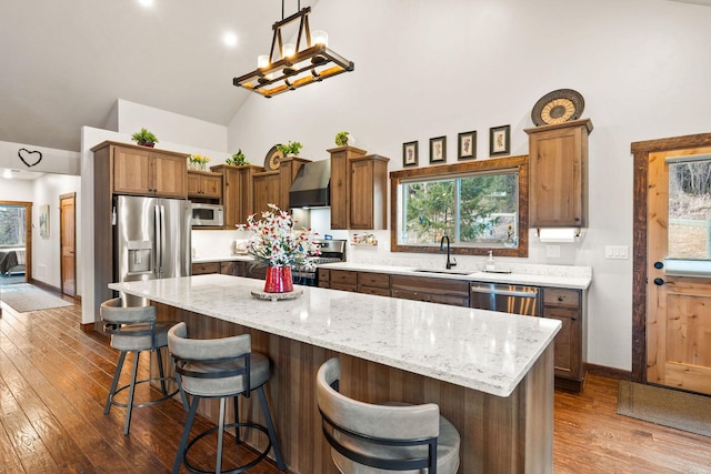 378 Skookum Rd, Lakeside, MT 59922 - kitchen with a sink, high vaulted ceiling, wall chimney range hood, appliances with stainless steel finishes, and dark wood finished floors