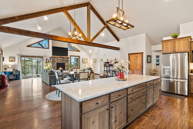 378 Skookum Rd, Lakeside, MT 59922 - kitchen with stainless steel fridge, a chandelier, a fireplace, high vaulted ceiling, and open floor plan