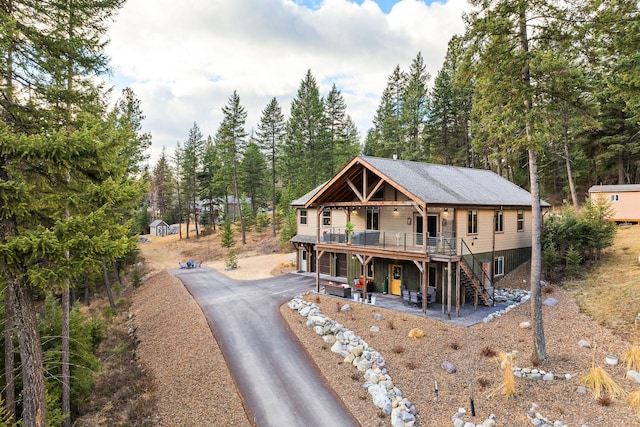 378 Skookum Rd, Lakeside, MT 59922 - view of front of home with a wooden deck, asphalt driveway, stairway, and a patio