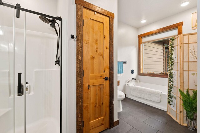 378 Skookum Rd, Lakeside, MT 59922 - full bath featuring a shower stall, toilet, tile patterned flooring, a garden tub, and recessed lighting
