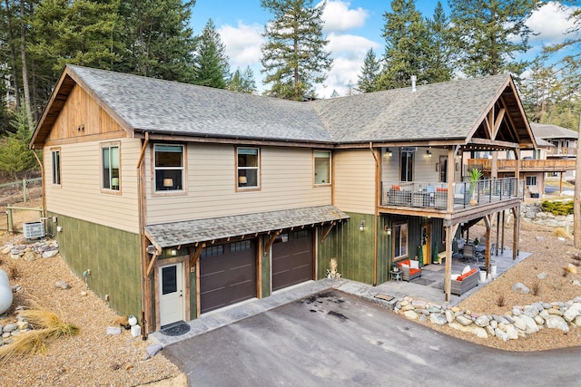 378 Skookum Rd, Lakeside, MT 59922 - view of front of property with a garage, central air condition unit, driveway, a balcony, and a shingled roof