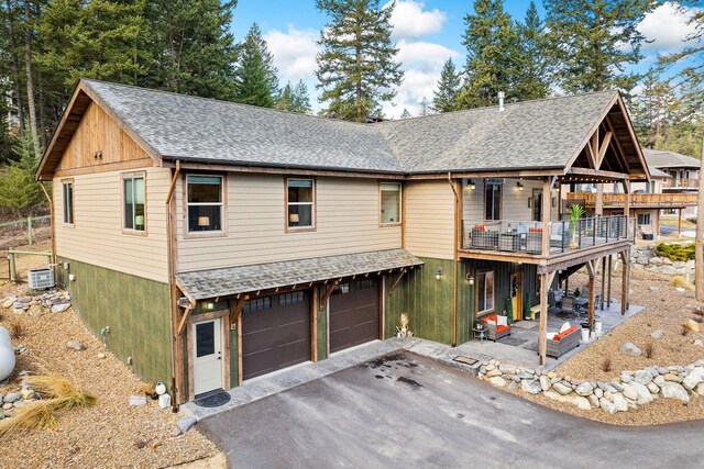 378 Skookum Rd, Lakeside, MT 59922 - view of front of home featuring an attached garage, driveway, a balcony, and a shingled roof