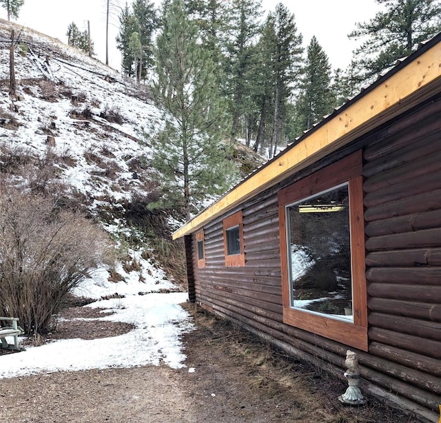 snow covered property with log exterior