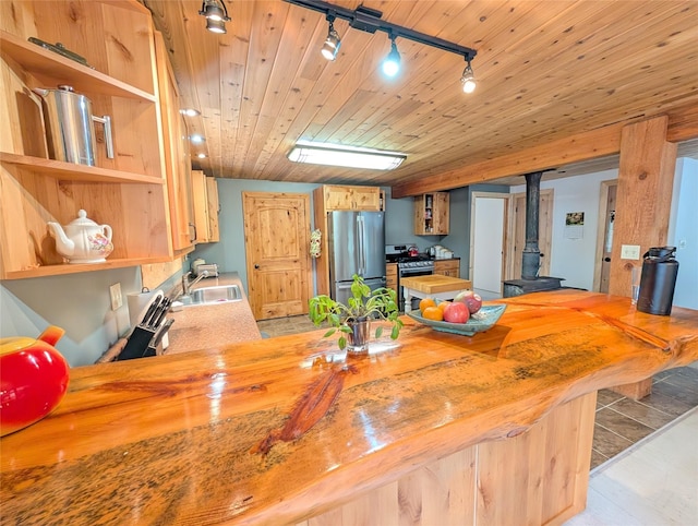 kitchen featuring open shelves, a wood stove, wood ceiling, a sink, and appliances with stainless steel finishes
