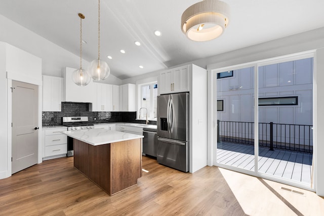 5665 Cattle Dr, Missoula, MT 59808 - kitchen with appliances with stainless steel finishes, a sink, a center island, decorative backsplash, and white cabinets