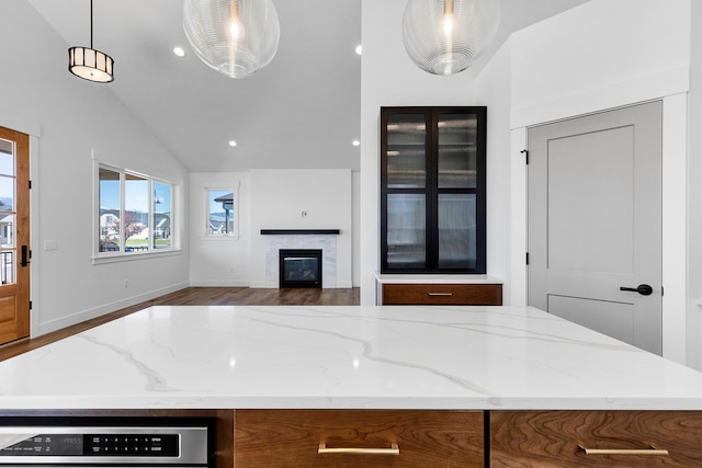 5665 Cattle Dr, Missoula, MT 59808 - kitchen with lofted ceiling, light stone countertops, a glass covered fireplace, pendant lighting, and open floor plan
