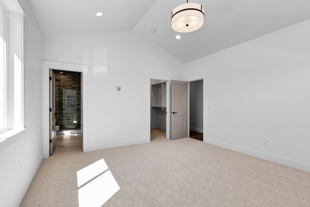 5665 Cattle Dr, Missoula, MT 59808 - unfurnished bedroom with light colored carpet, high vaulted ceiling, a walk in closet, baseboards, and a closet