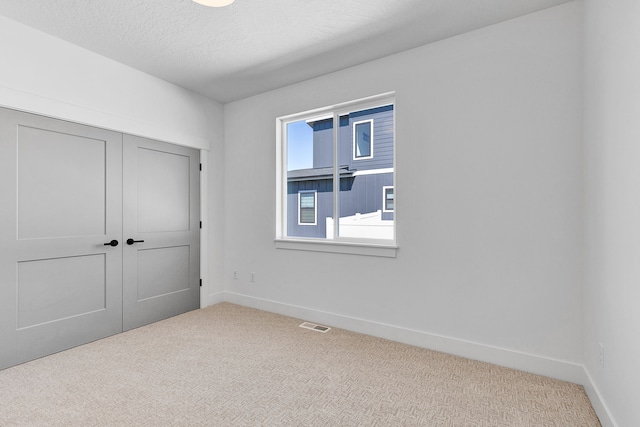 5665 Cattle Dr, Missoula, MT 59808 - unfurnished bedroom with carpet floors, baseboards, a closet, and a textured ceiling