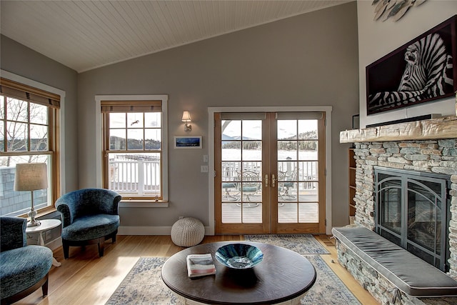 23877 3rd St, Dayton, MT 59914 - living room with vaulted ceiling, plenty of natural light, wood finished floors, french doors, and a stone fireplace