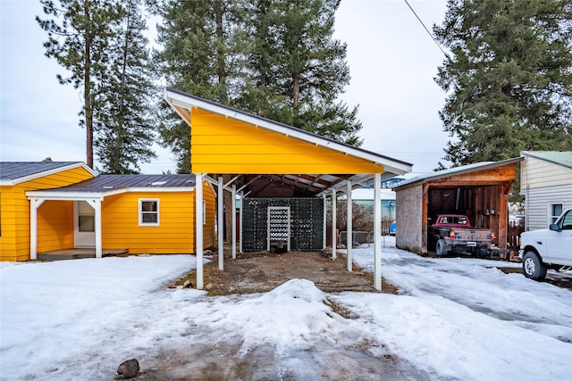 1613 Main Ave, Libby, MT 59923 - view of snowy exterior featuring a detached carport