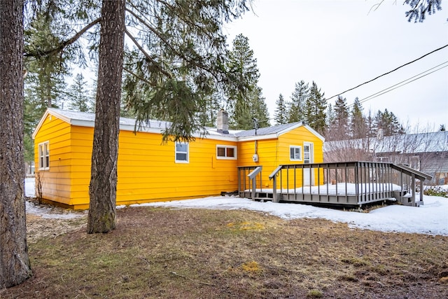 1613 Main Ave, Libby, MT 59923 - snow covered back of property with a wooden deck and a chimney